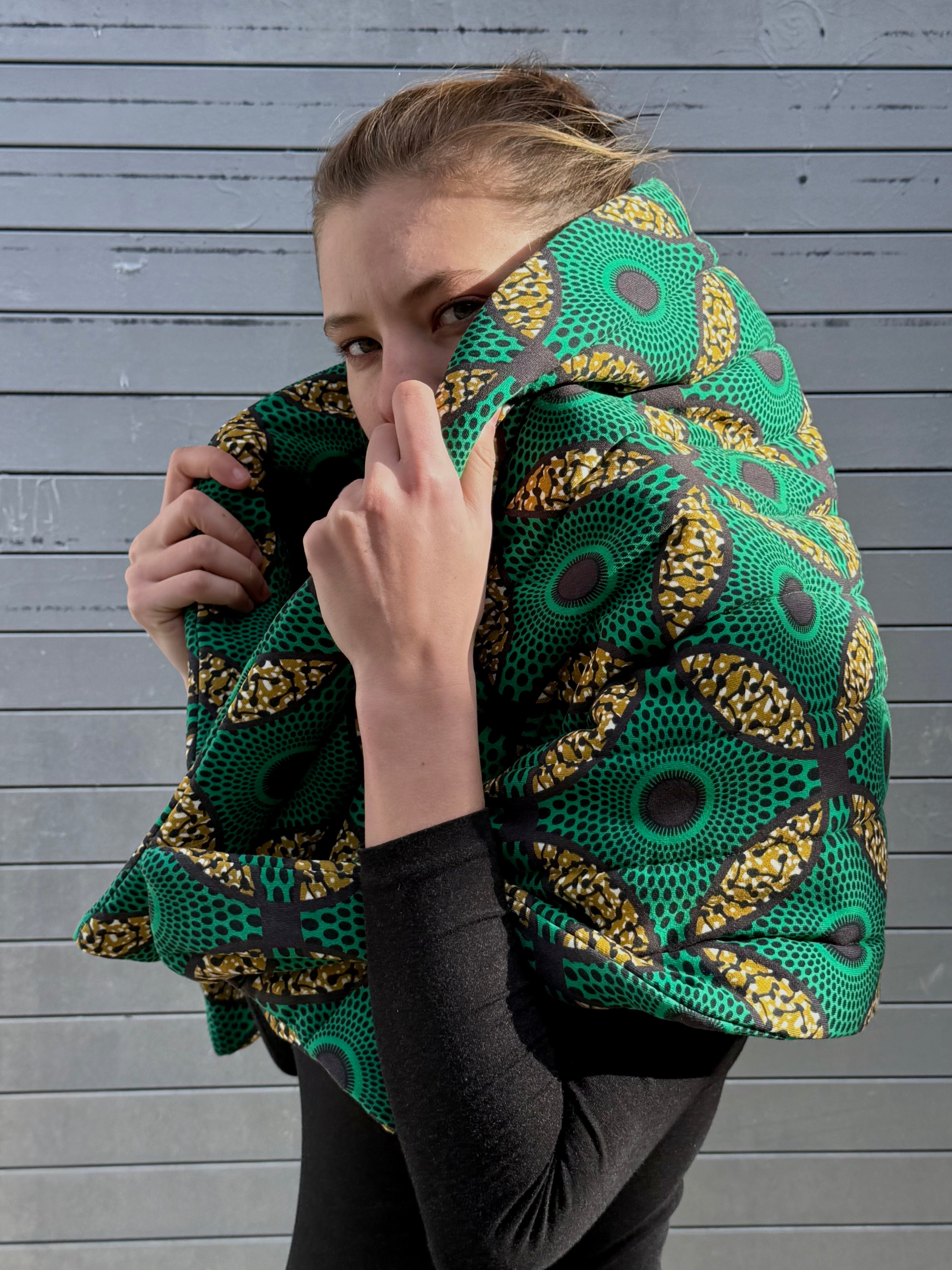 Close-up of the Ìmọ́lẹ̀ Green Scarf featuring bold African-inspired prints in emerald and golden tones. Designed by Lola Faturoti Loves, this handcrafted organic cotton scarf blends softness, sustainability, and cultural storytelling in every stitch.